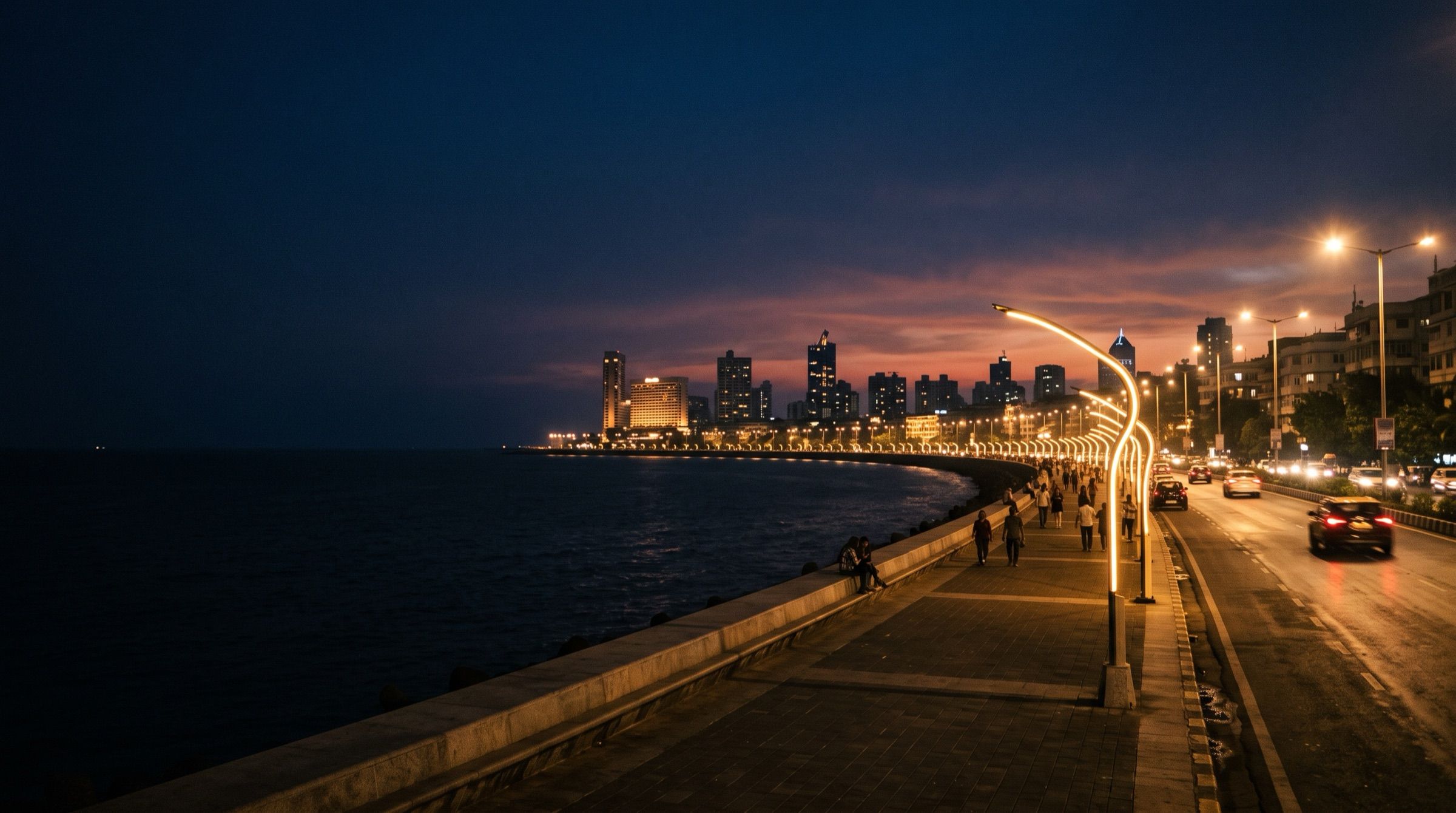 Marine Drive in Mumbai at dusk with the curved line of street lights along the sea