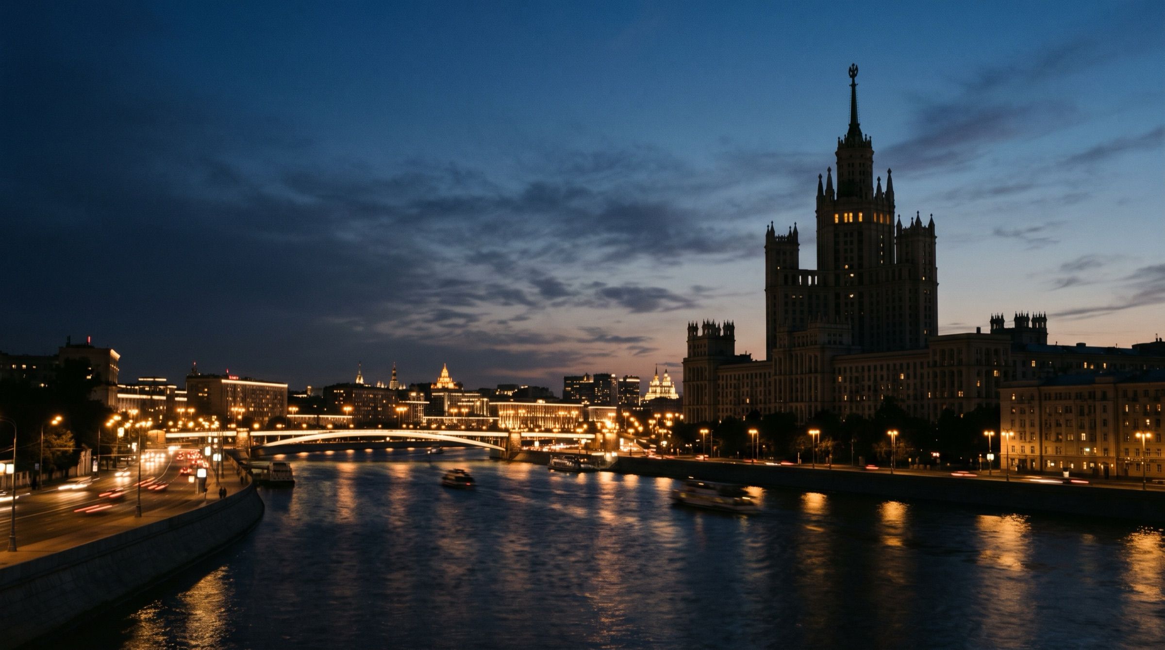 The Moskva river at dusk with a monumental Stalinist skyscraper silhouette and city lights