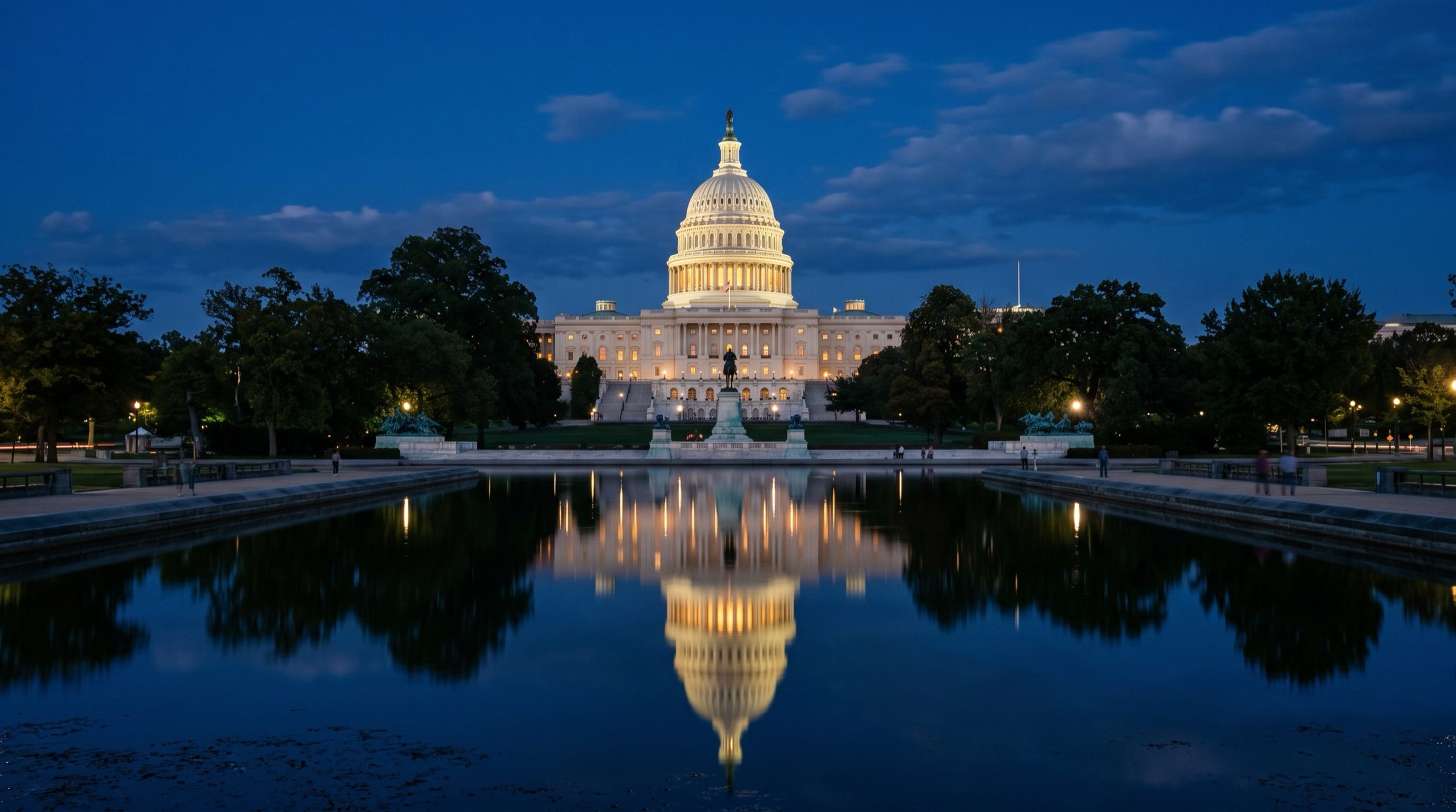 The United States Capitol dome at blue hour seen across a reflecting pool, warm lights on the facade